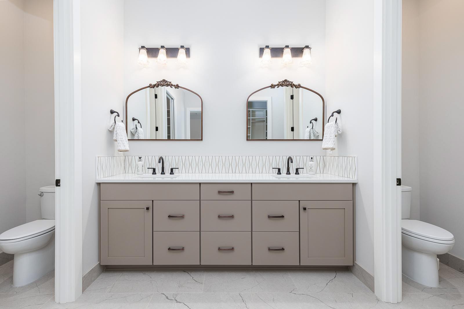 Modern bathroom with dual sinks and mirrors.