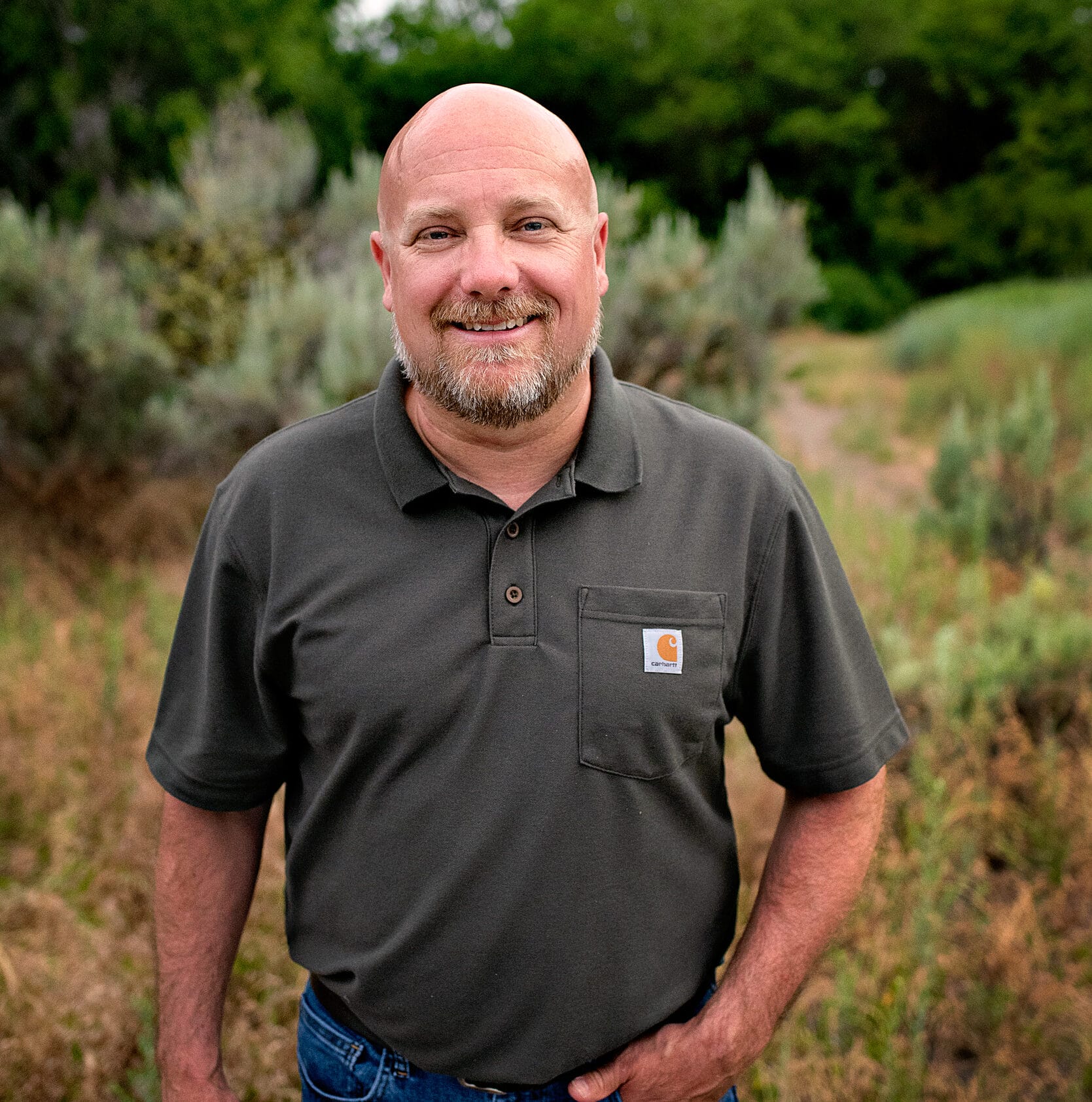 Man smiling outdoors in casual attire