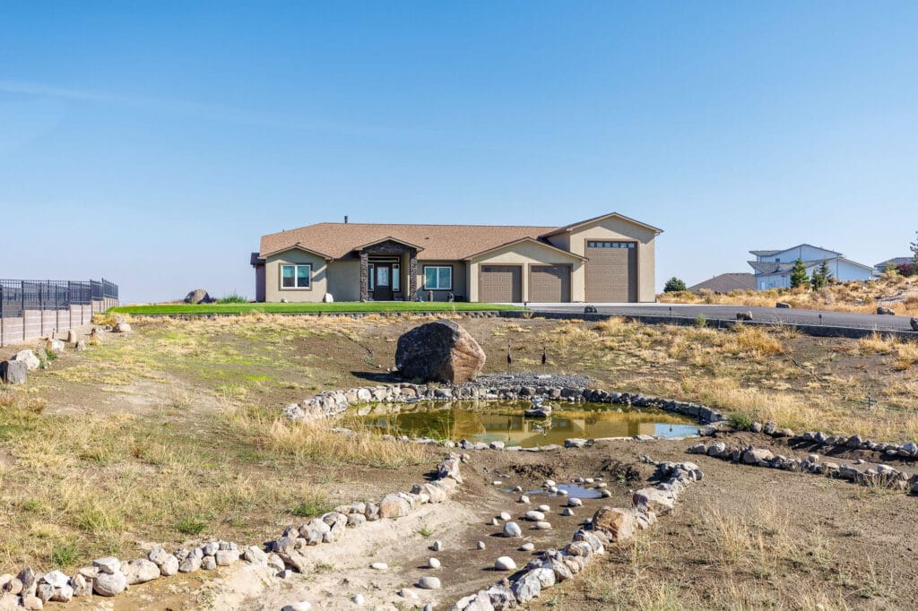 Modern ranch-style house with a small pond.