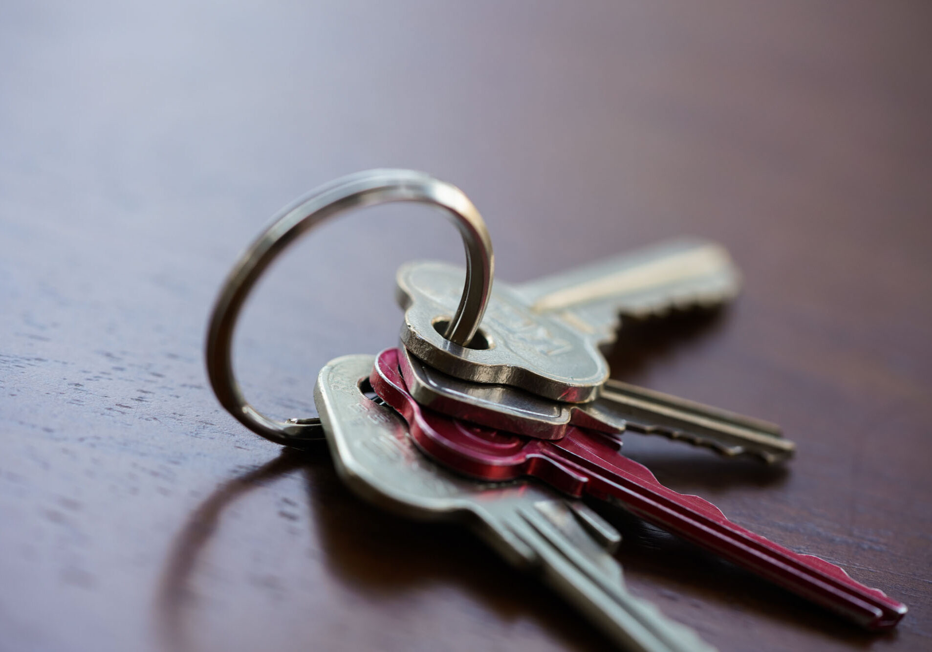 Close-up of metal keys on wooden table.